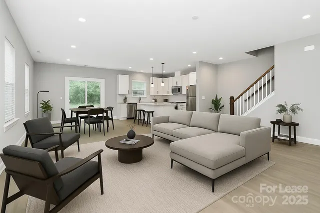 a living room with furniture and a view of kitchen