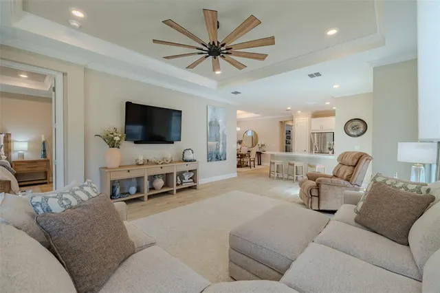 a living room with furniture and a flat screen tv with kitchen view