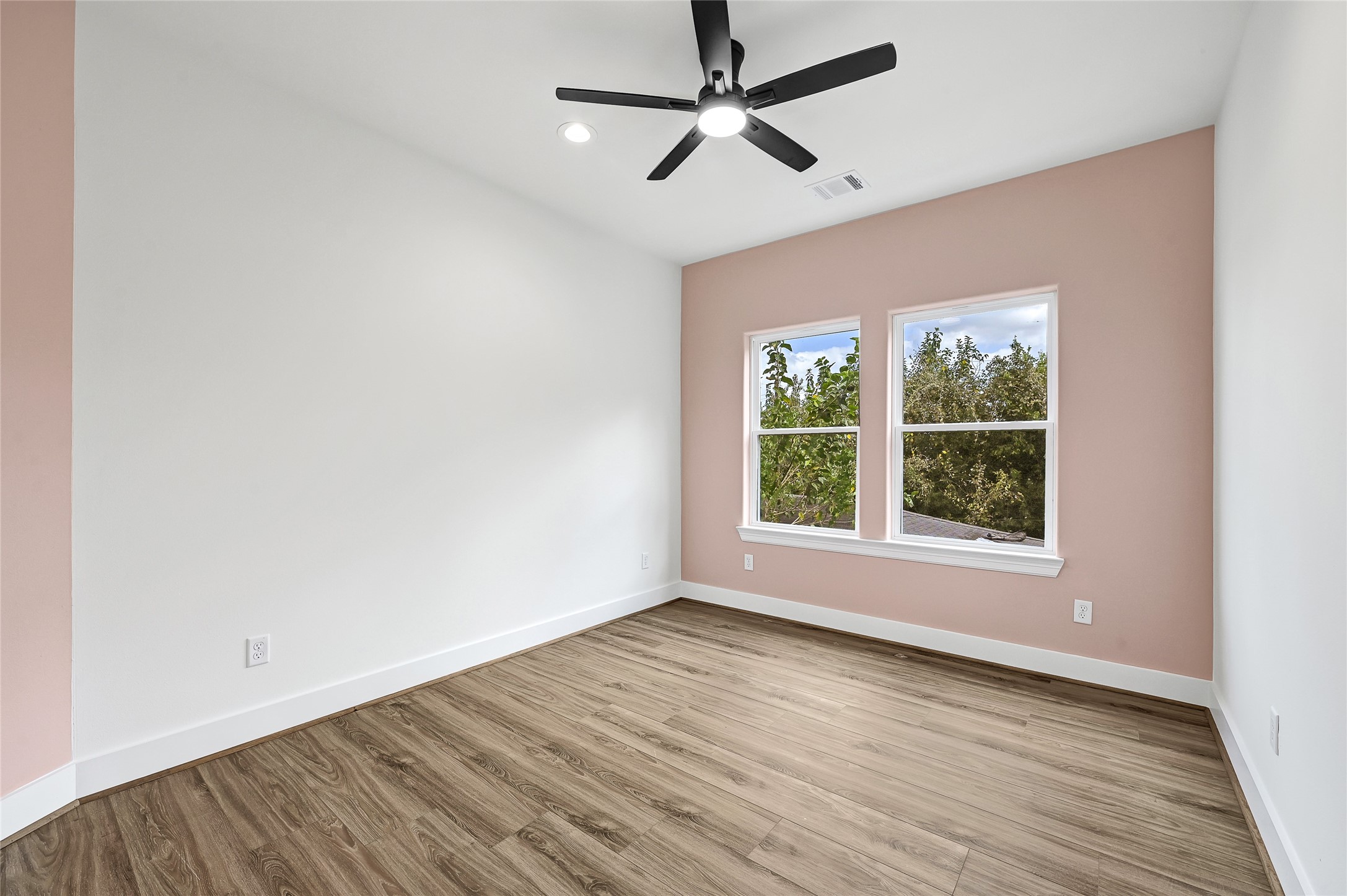 3834 Mt Pleasant Street Houston, TX 77021 - Photo 25 of 50 an empty room with wooden floor ceiling fan and windows