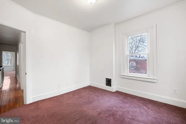 an empty room with windows and closet