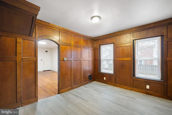 a view of an empty room with glass door and wooden floor