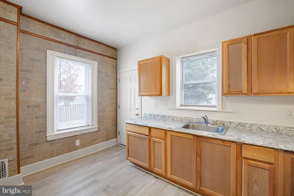a kitchen with granite countertop wooden cabinets a sink and a window