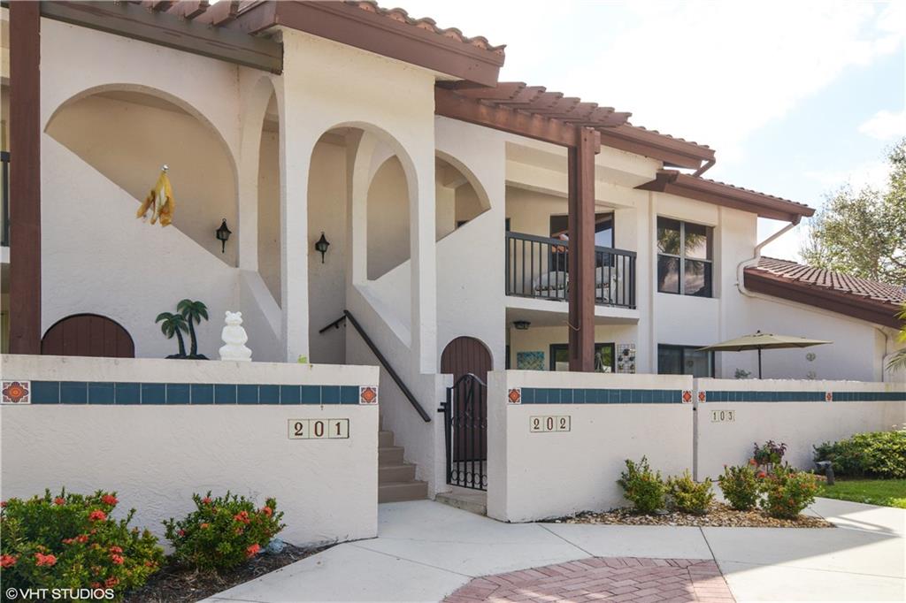 3410 Southeast Martinique Trace, Unit 202 Stuart, FL 34997 - Photo 1 of 15 a front view of a house with garden