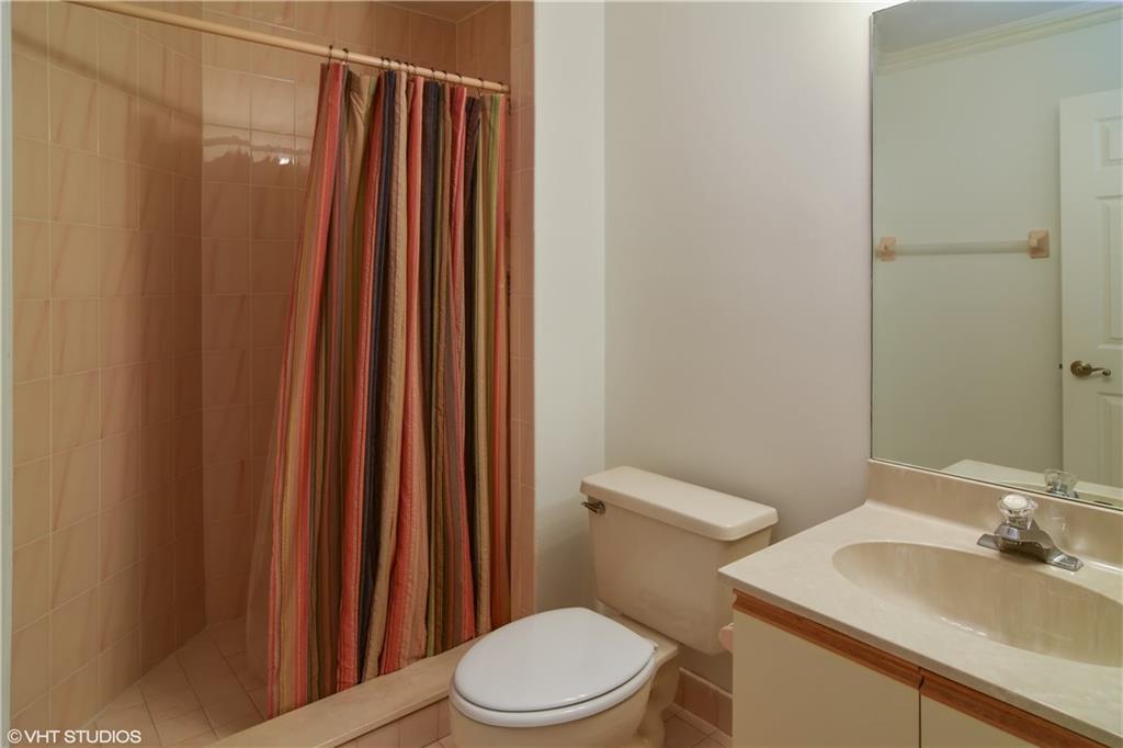 3410 Southeast Martinique Trace, Unit 202 Stuart, FL 34997 - Photo 13 of 15 a white toilet sitting next to a bathroom sink