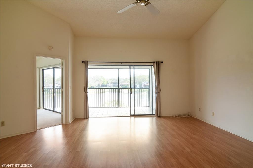 3410 Southeast Martinique Trace, Unit 202 Stuart, FL 34997 - Photo 3 of 15 an empty room with wooden floor and windows