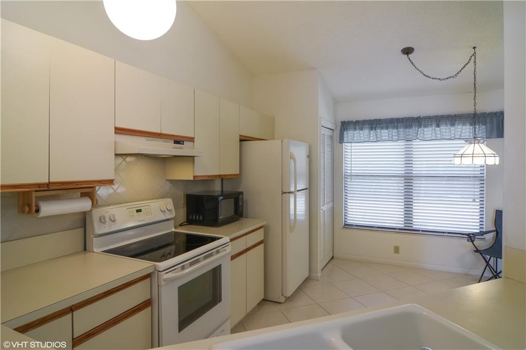 3410 Southeast Martinique Trace, Unit 202 Stuart, FL 34997 - Photo 8 of 15 a kitchen with a stove a refrigerator and a sink
