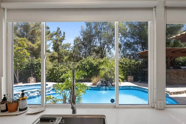 a kitchen with stainless steel appliances a dining table chairs and wooden floor