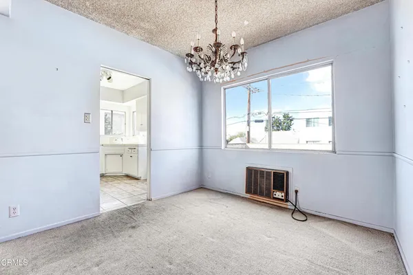 an empty room with windows and chandelier