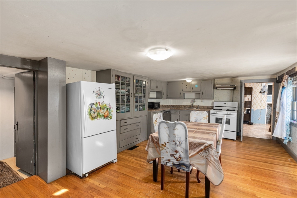 52 Salem Street Reading, MA 01867 - Photo 11 of 26 a kitchen with stainless steel appliances a refrigerator a stove a dining table and chairs