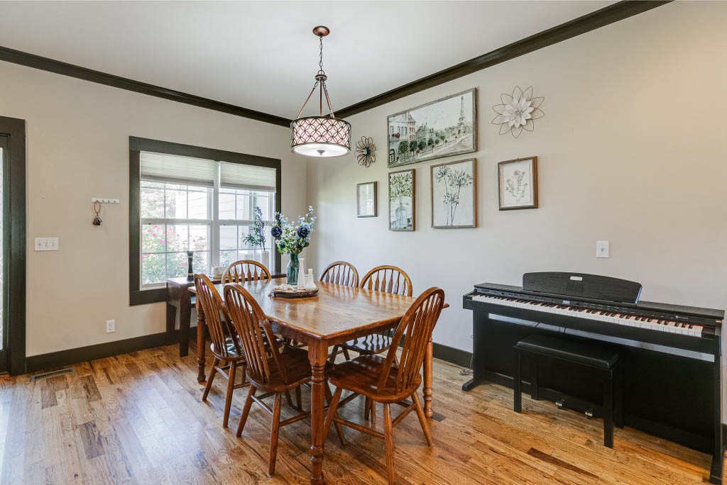 124 Riley Creek Road Tullahoma, TN 37388 - Photo 11 of 30 a dining room with wooden floor a chandelier a wooden table and chairs