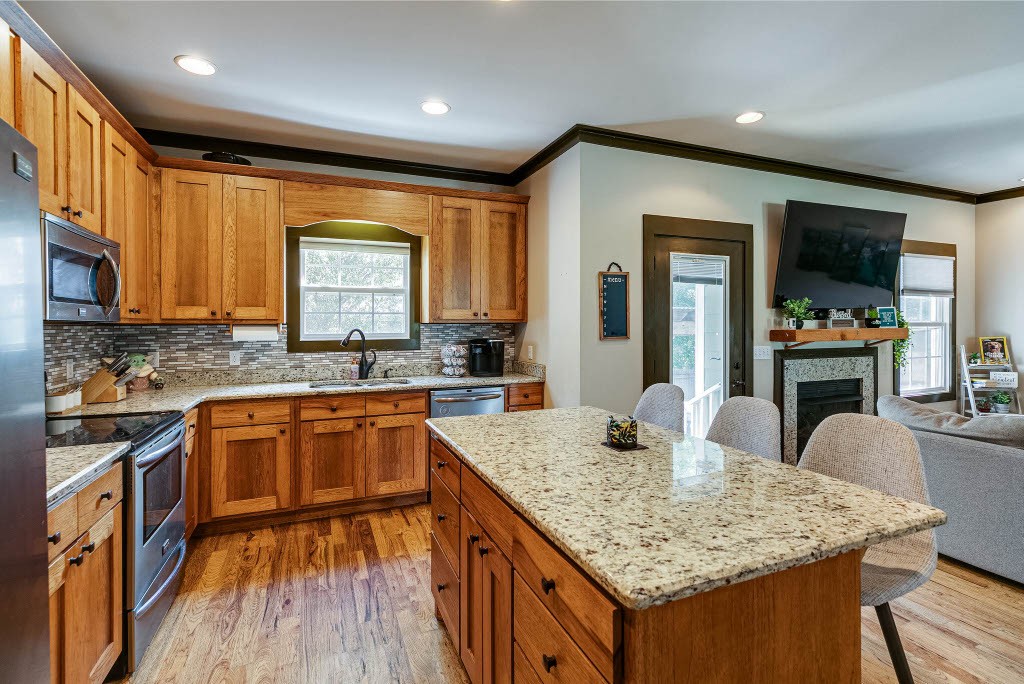 124 Riley Creek Road Tullahoma, TN 37388 - Photo 8 of 30 a kitchen with kitchen island granite countertop a sink cabinets and wooden floor