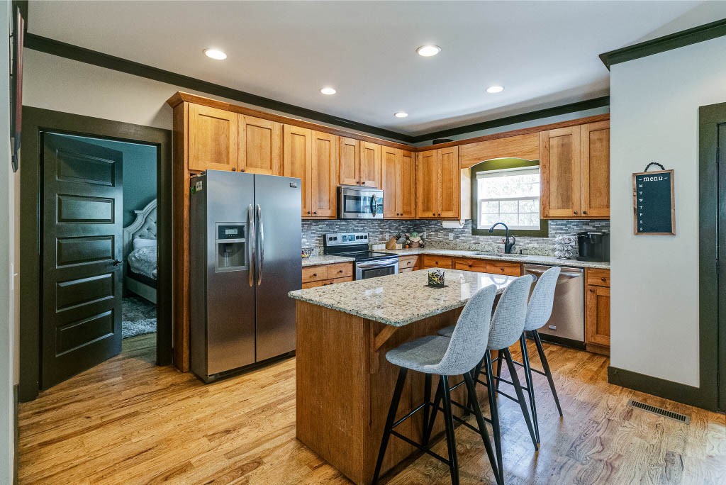 124 Riley Creek Road Tullahoma, TN 37388 - Photo 9 of 30 a kitchen with stainless steel appliances granite countertop a refrigerator a stove a sink and a dining table with wooden floor