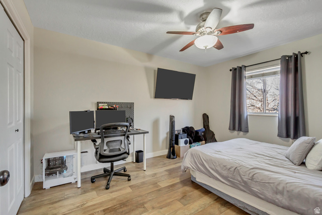 933 South Freedom Boulevard, Unit 7 Provo, UT 84601 - Photo 11 of 23 Bedroom with light wood-style flooring, a ceiling fan, an office area, a closet, and a textured ceiling