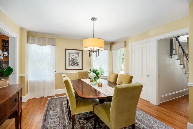 a dining room with furniture window and wooden floor
