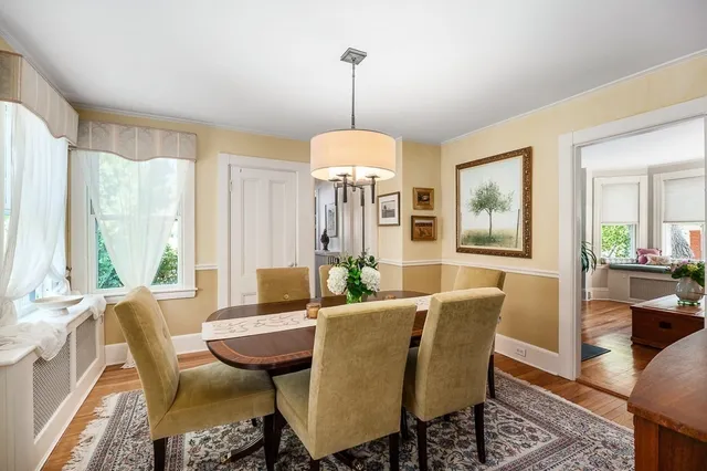 a dining room with furniture a chandelier and wooden floor