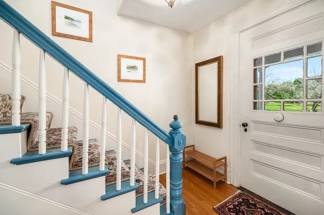 a view of staircase with lots of frames on wall and a large window