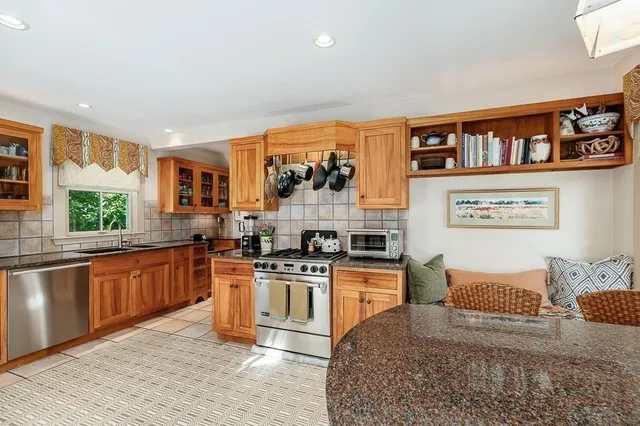 a large kitchen with stainless steel appliances granite countertop a stove and a sink