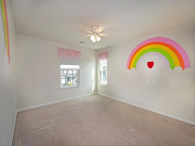 a view of empty room with window and ceiling fan