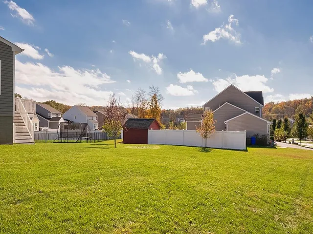a view of a house with a big yard and a large tree