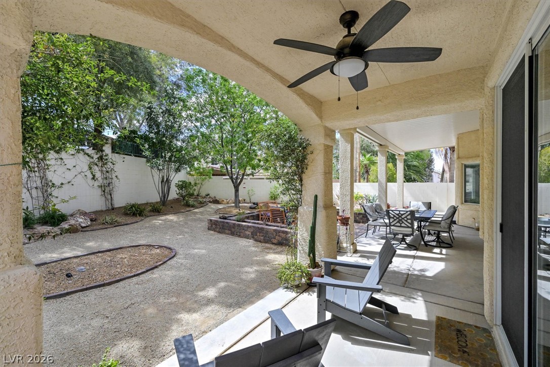 1259 Moon Vision Street Henderson, NV 89052 - Photo 39 of 53 An inviting covered patio opens to a gravel yard featuring a fire pit and mature landscaping.