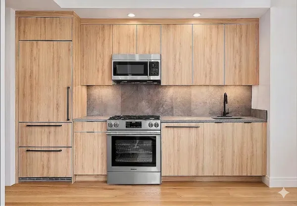 a kitchen with stainless steel appliances a stove a microwave and a refrigerator