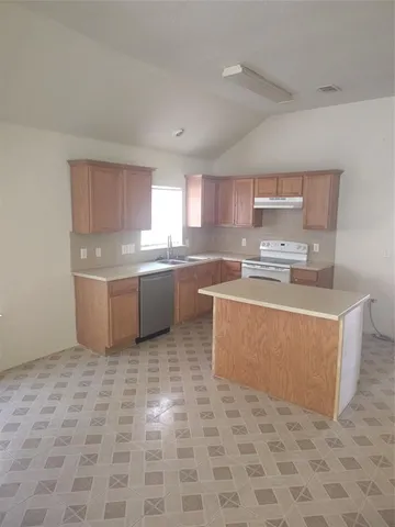 a kitchen with stainless steel appliances a sink a stove a microwave a sink a counter top space and cabinets