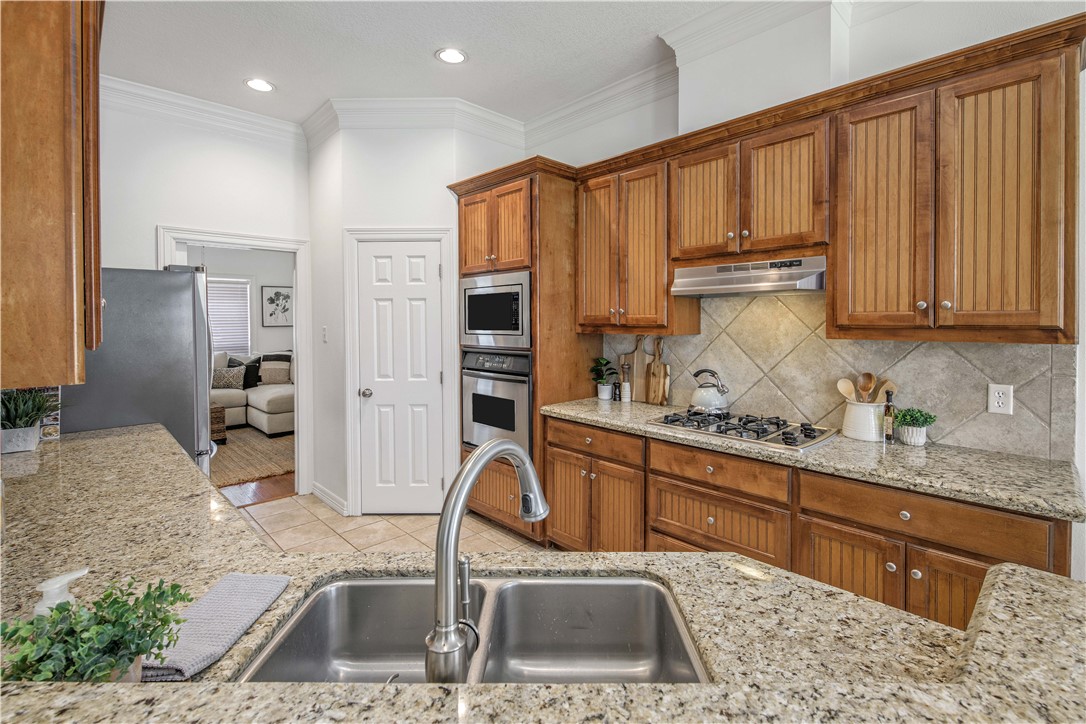 406 Cold Spring Drive College Station, TX 77845 - Photo 11 of 32 a kitchen with stainless steel appliances granite countertop a sink refrigerator and cabinets