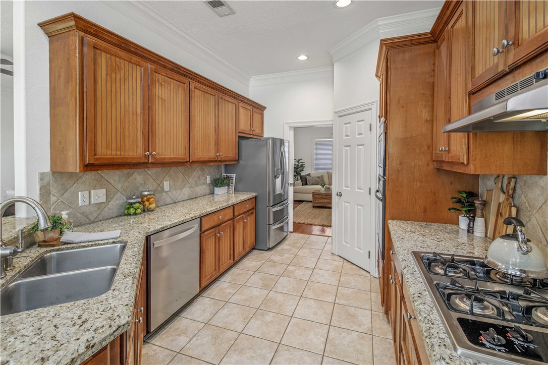 406 Cold Spring Drive College Station, TX 77845 - Photo 12 of 32 a kitchen with stainless steel appliances granite countertop a stove a sink and a refrigerator