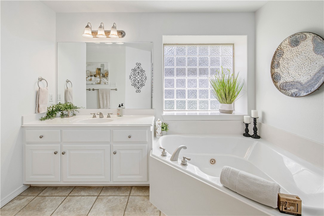 406 Cold Spring Drive College Station, TX 77845 - Photo 17 of 32 a bathroom with a tub a sink and a mirror