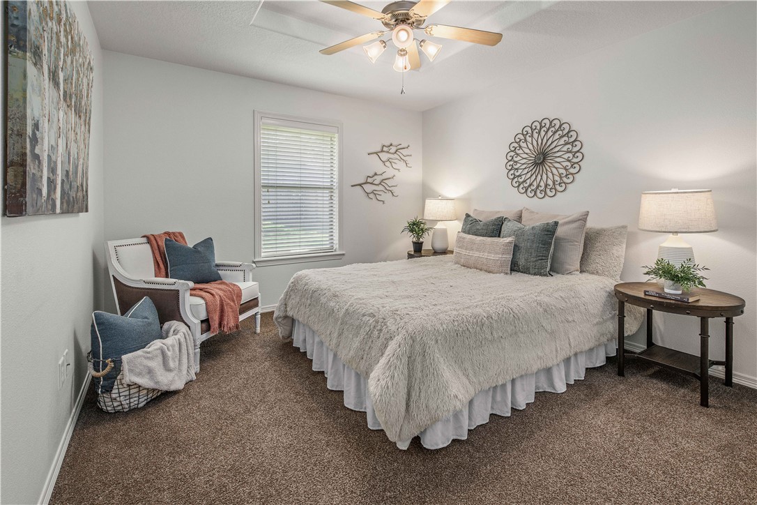 406 Cold Spring Drive College Station, TX 77845 - Photo 23 of 32 a spacious bedroom with a bed and a chandelier