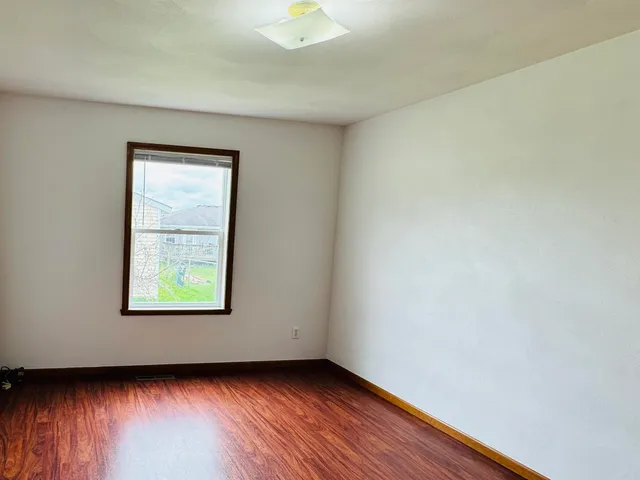 an empty room with wooden floor and closet