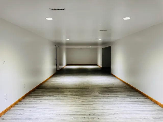 a view of empty room with wooden floor