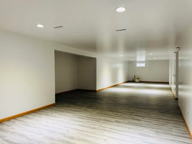 a view of an empty room with wooden floor