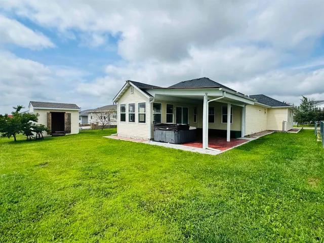 a view of a patio with a table chair potted plants and floor to ceiling window