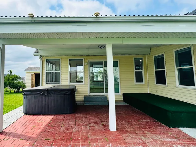 a white house with a yard potted plants and a table