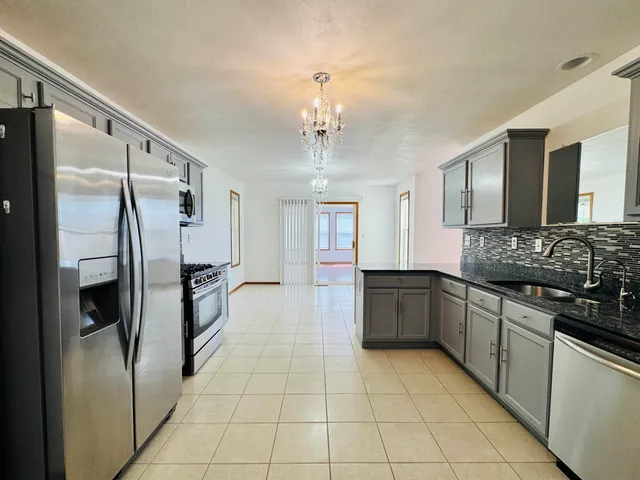 a kitchen with stainless steel appliances granite countertop a sink and stove top oven