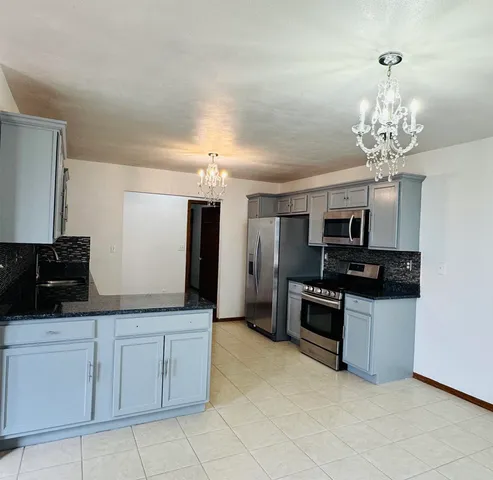 a kitchen with stainless steel appliances granite countertop a sink and dishwasher a stove with wooden floor