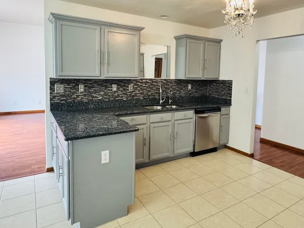 a kitchen with cabinets stainless steel appliances and wooden floor