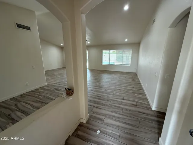 a view of a hallway with wooden floor and staircase