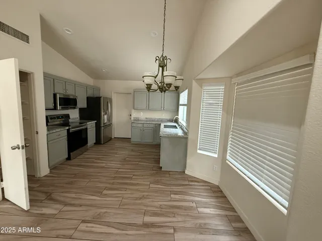 a kitchen with stainless steel appliances kitchen island granite countertop a refrigerator and a sink