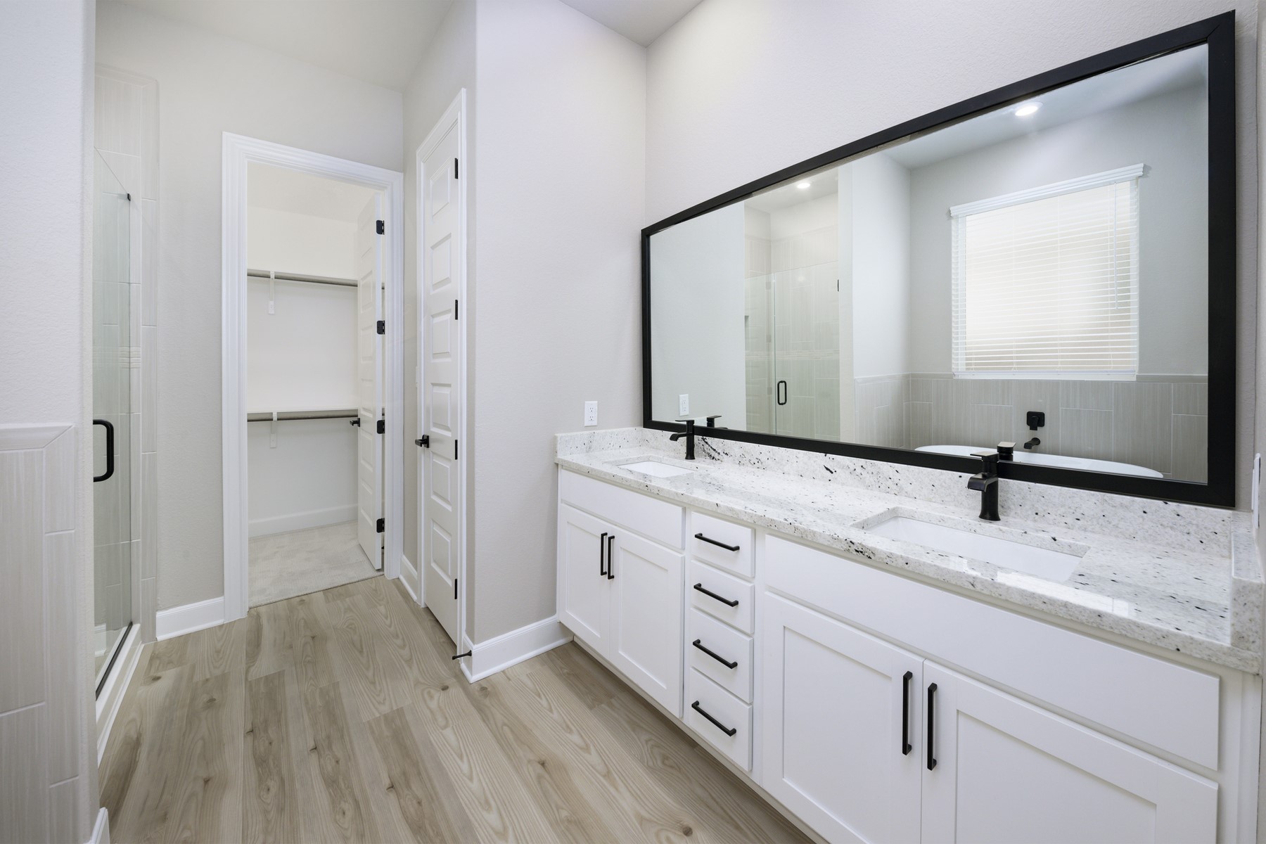 10622 Sutter Crk Drive Rosharon, TX 77583 - Photo 11 of 28 This space features a massive dual-sink vanity with granite countertops, sleek black fixtures, and a direct entrance to your generous walk-in closet.