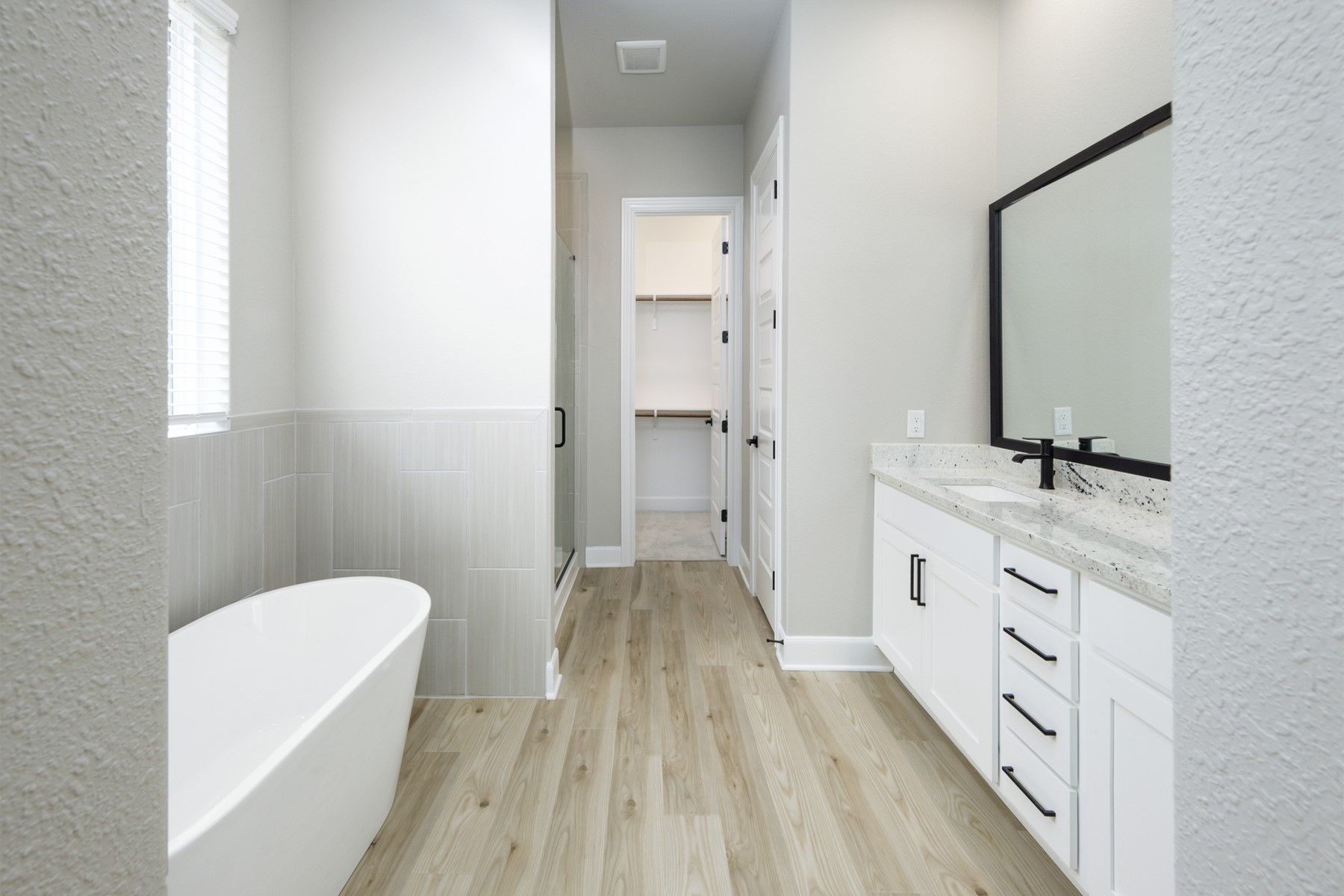 10622 Sutter Crk Drive Rosharon, TX 77583 - Photo 13 of 28 This angle highlights the generous floor space, beautiful wood-look tile, and the perfect layout that connects your spa-inspired soaking tub to the massive walk-in closet.