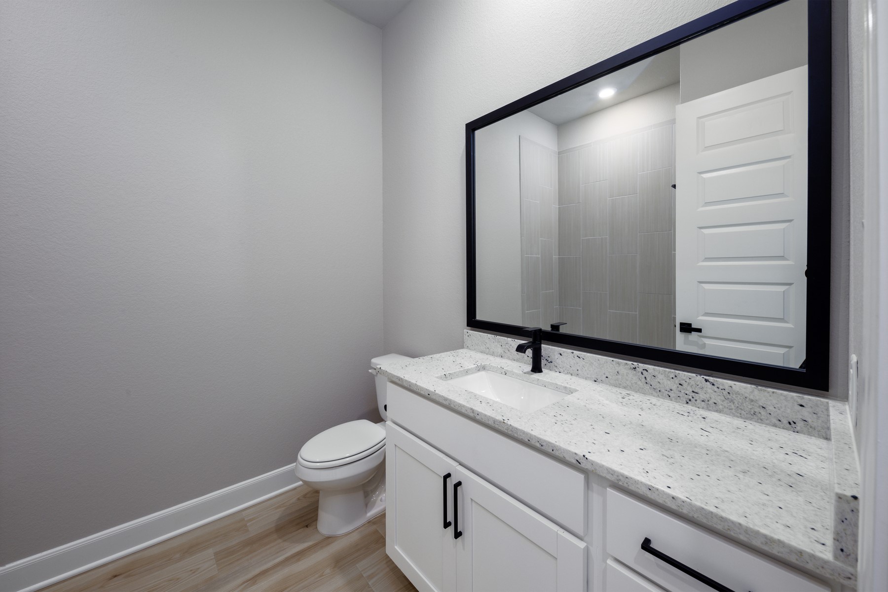 10622 Sutter Crk Drive Rosharon, TX 77583 - Photo 16 of 28 The secondary bathroom doesn't skimp on style! Enjoy the same high-end finishes found throughout the home, including premium granite countertops, sleek black hardware, and a framed mirror that adds a modern touch for guests and family alike.
