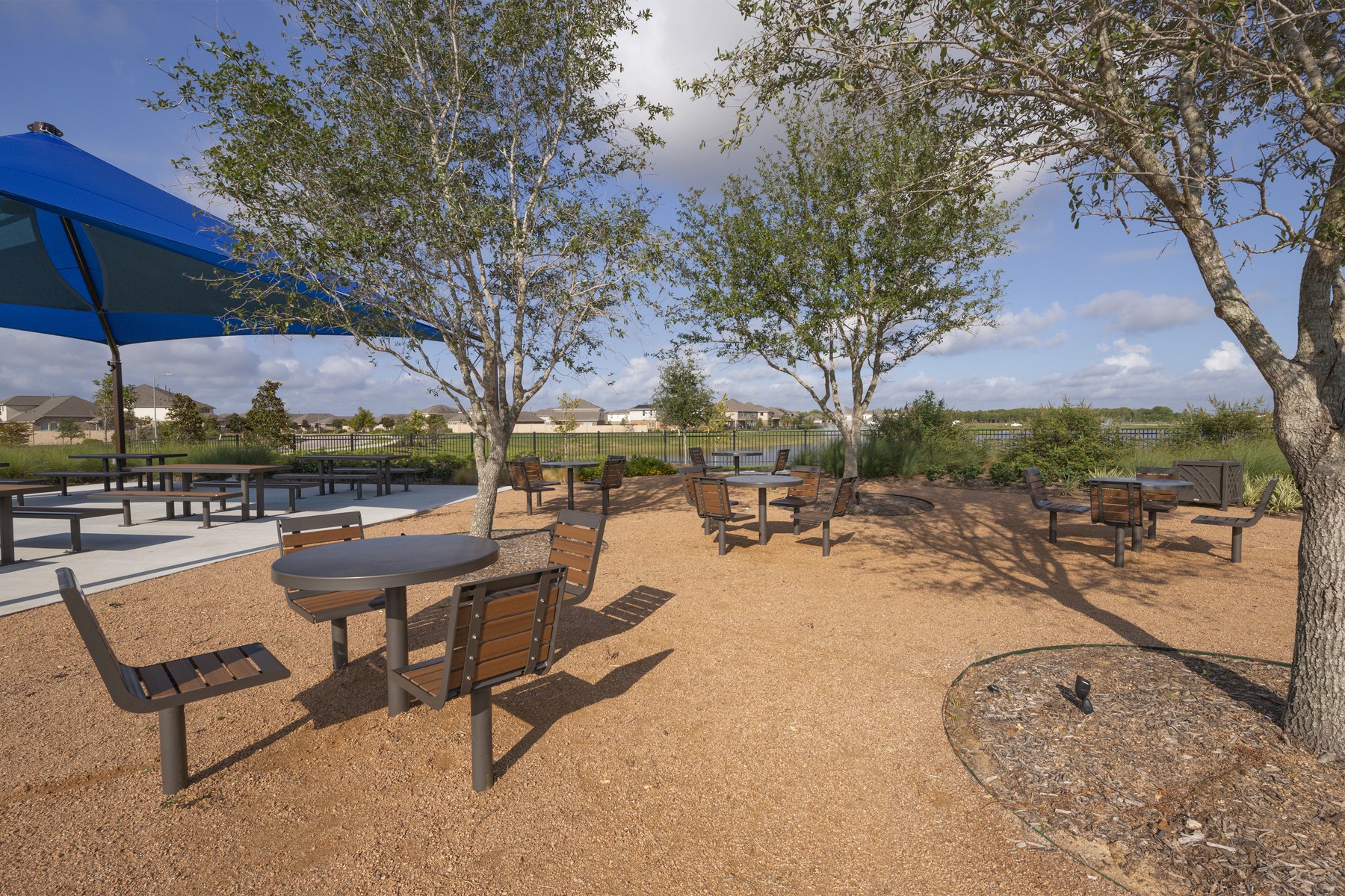 10622 Sutter Crk Drive Rosharon, TX 77583 - Photo 26 of 28 This alternate view of the Sierra Vista picnic area highlights the generous seating and professional landscaping, offering residents a peaceful, shaded retreat to enjoy the fresh air and neighborhood views.