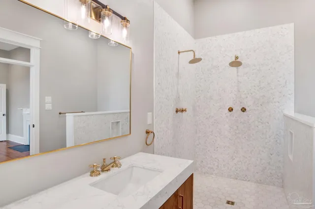 a bathroom with a sink shower and a mirror