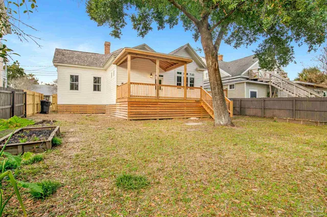 a view of a white house with a yard