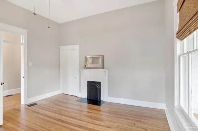 a view of empty room with wooden floor and fireplace