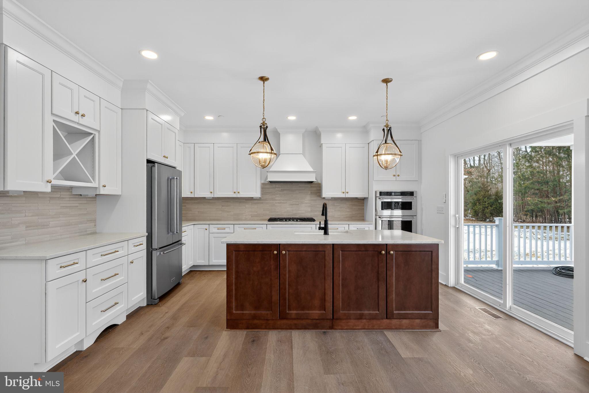 27458 Mooring Way Salisbury, MD 21801 - Photo 12 of 32 a large kitchen with kitchen island a sink stainless steel appliances and cabinets