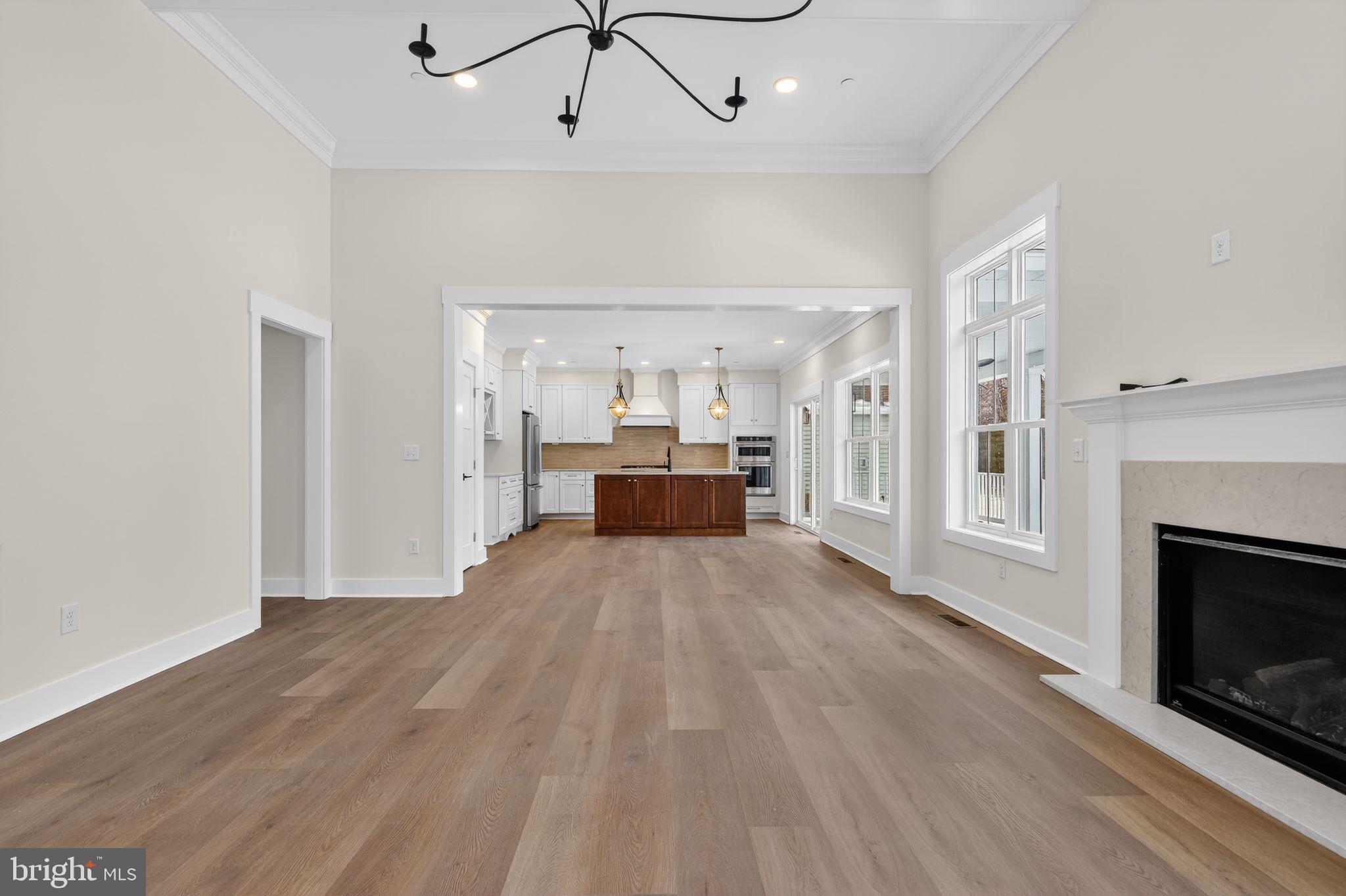 27458 Mooring Way Salisbury, MD 21801 - Photo 6 of 32 a view of a livingroom with a fireplace a chandelier and wooden floor