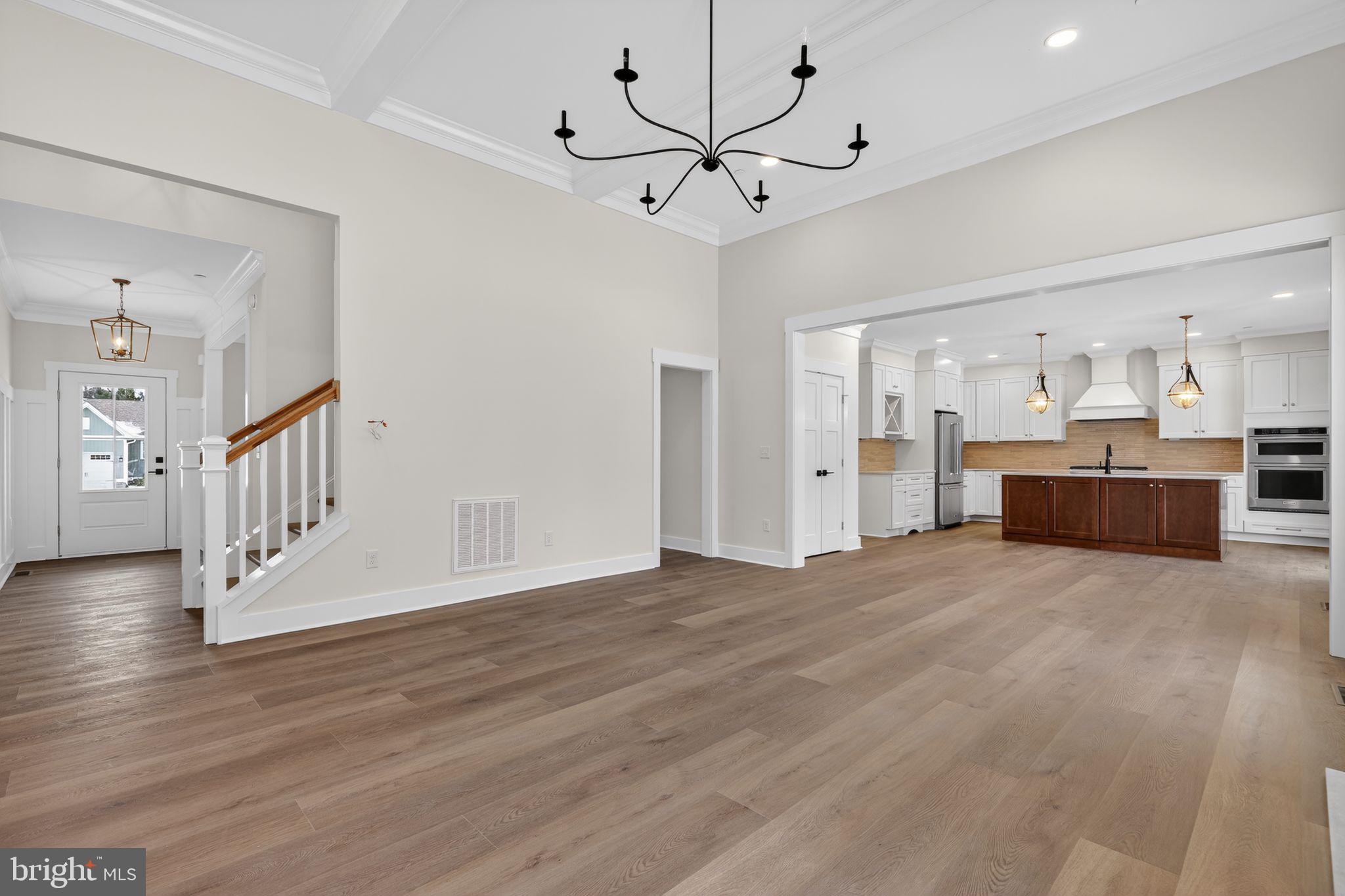 27458 Mooring Way Salisbury, MD 21801 - Photo 7 of 32 a view of an empty room with wooden floor and a kitchen